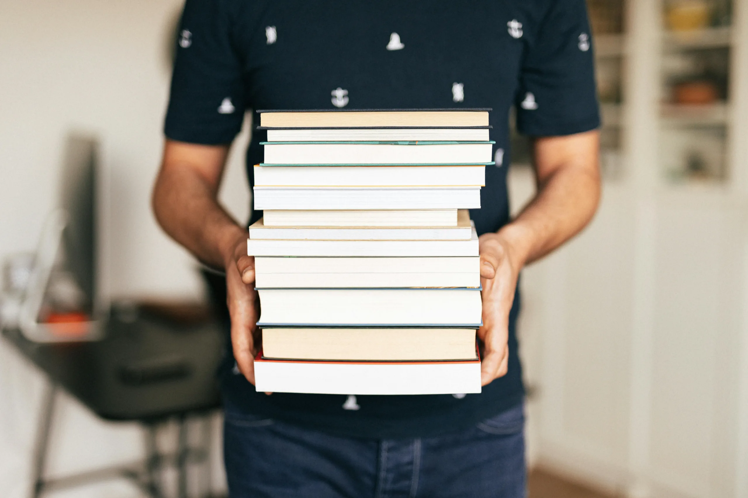 man with a stack of books 