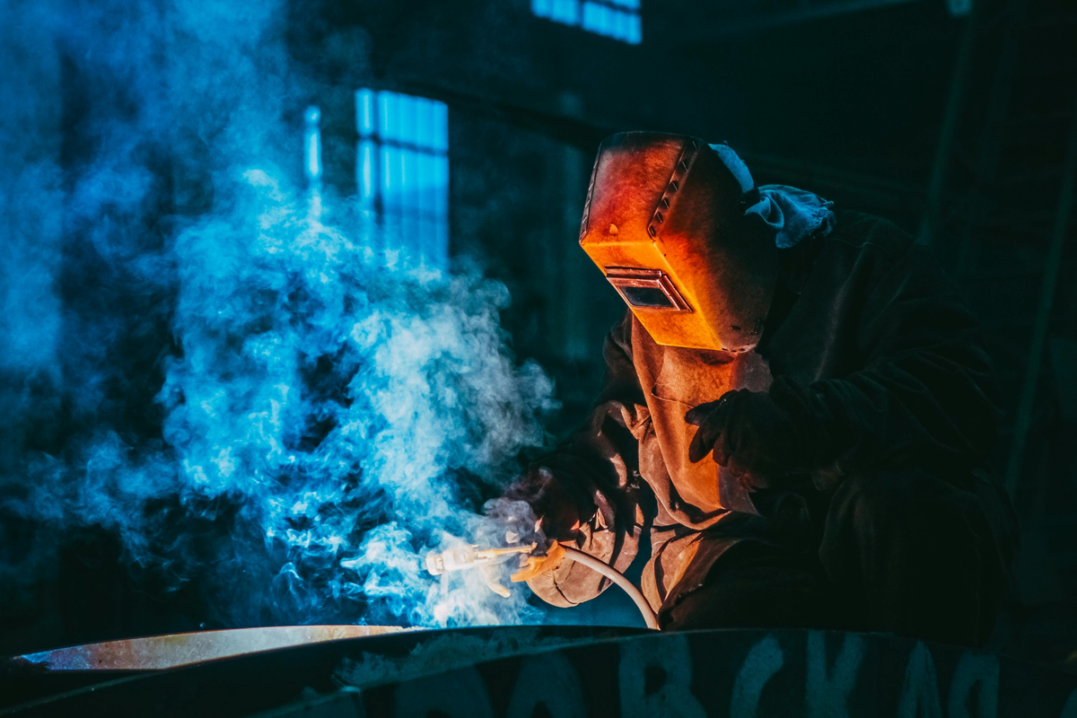 Welder with red and blue smoke