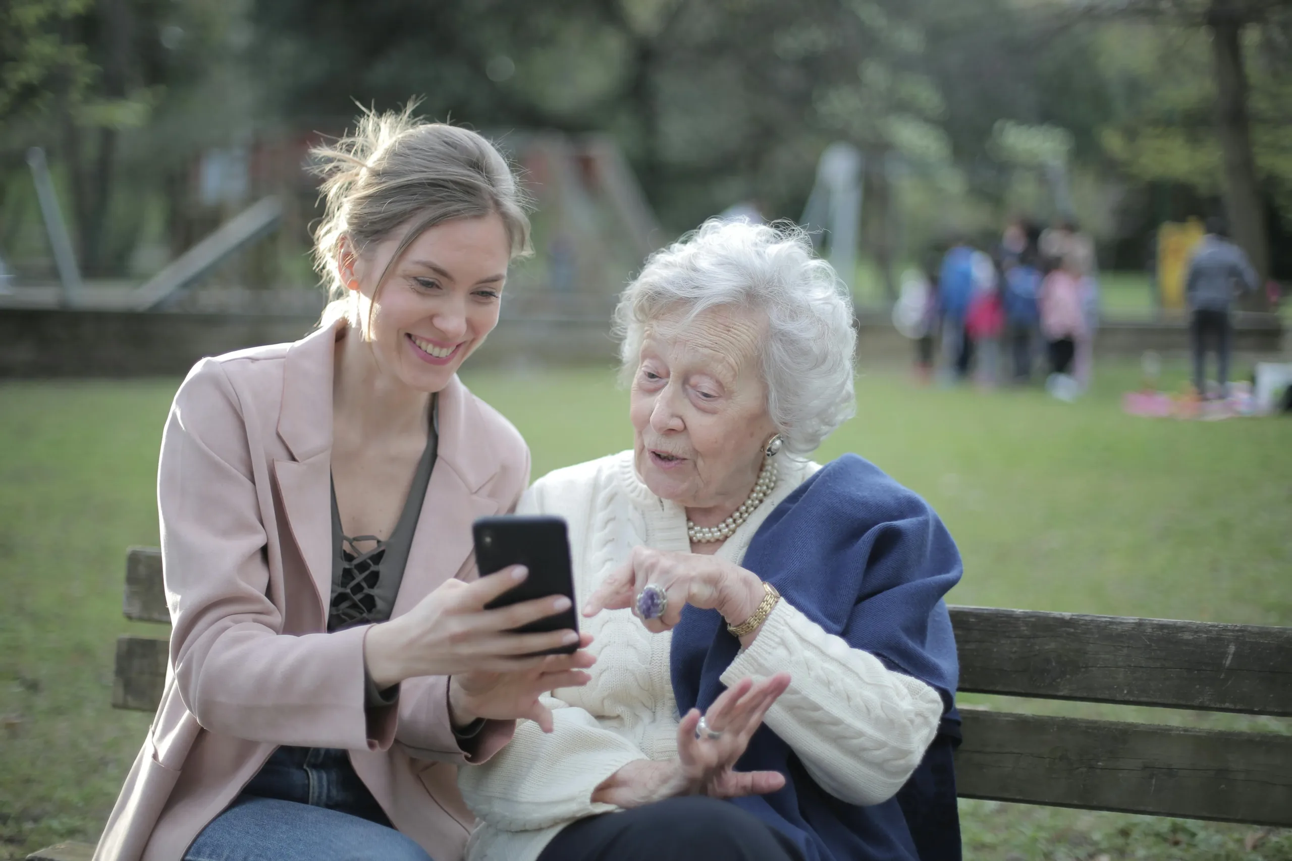woman helping another use an iphone