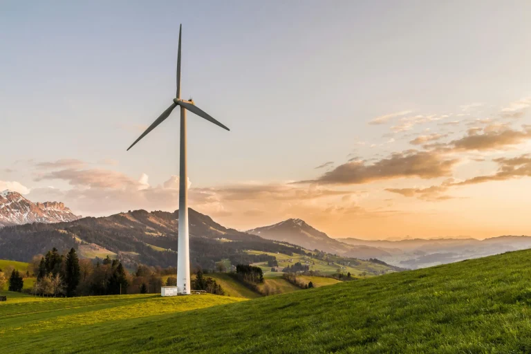 Wind turbine with mountains in the background and water in the distance, likely in California.