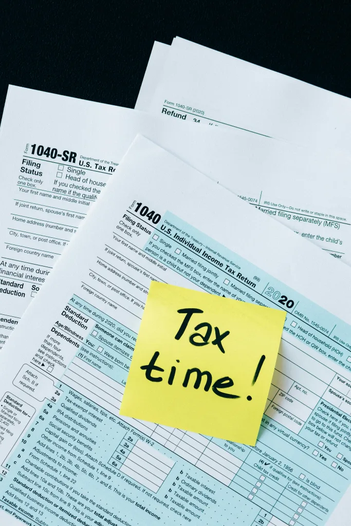 Tax papers with a sticky note on top that says 'tax time!' as someone strategizes for SALT deductions.