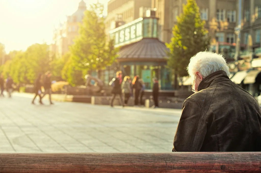 A prospective retiree is sitting on a bench in a sunny town square, thinking about his FERS supplement eligibility. 