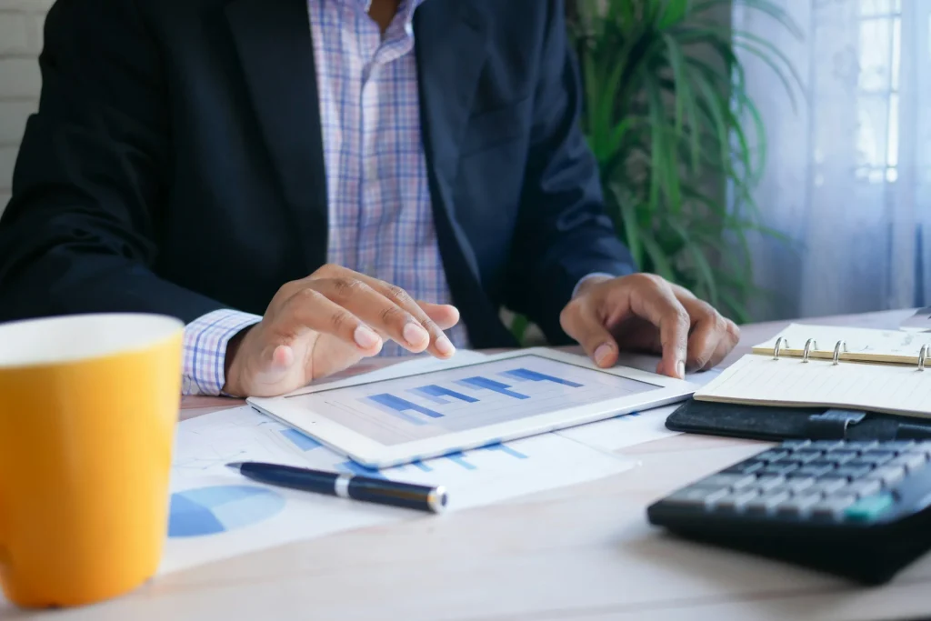 An accountant is using an iPad to monitor the bottom line and determine if their client should lease or finance.
